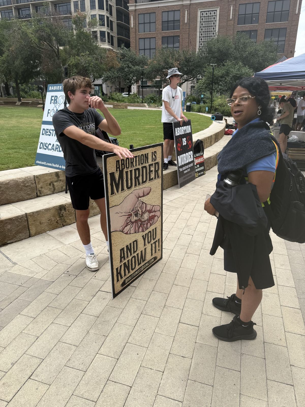 A young man with an abortion is murder sign in a city park