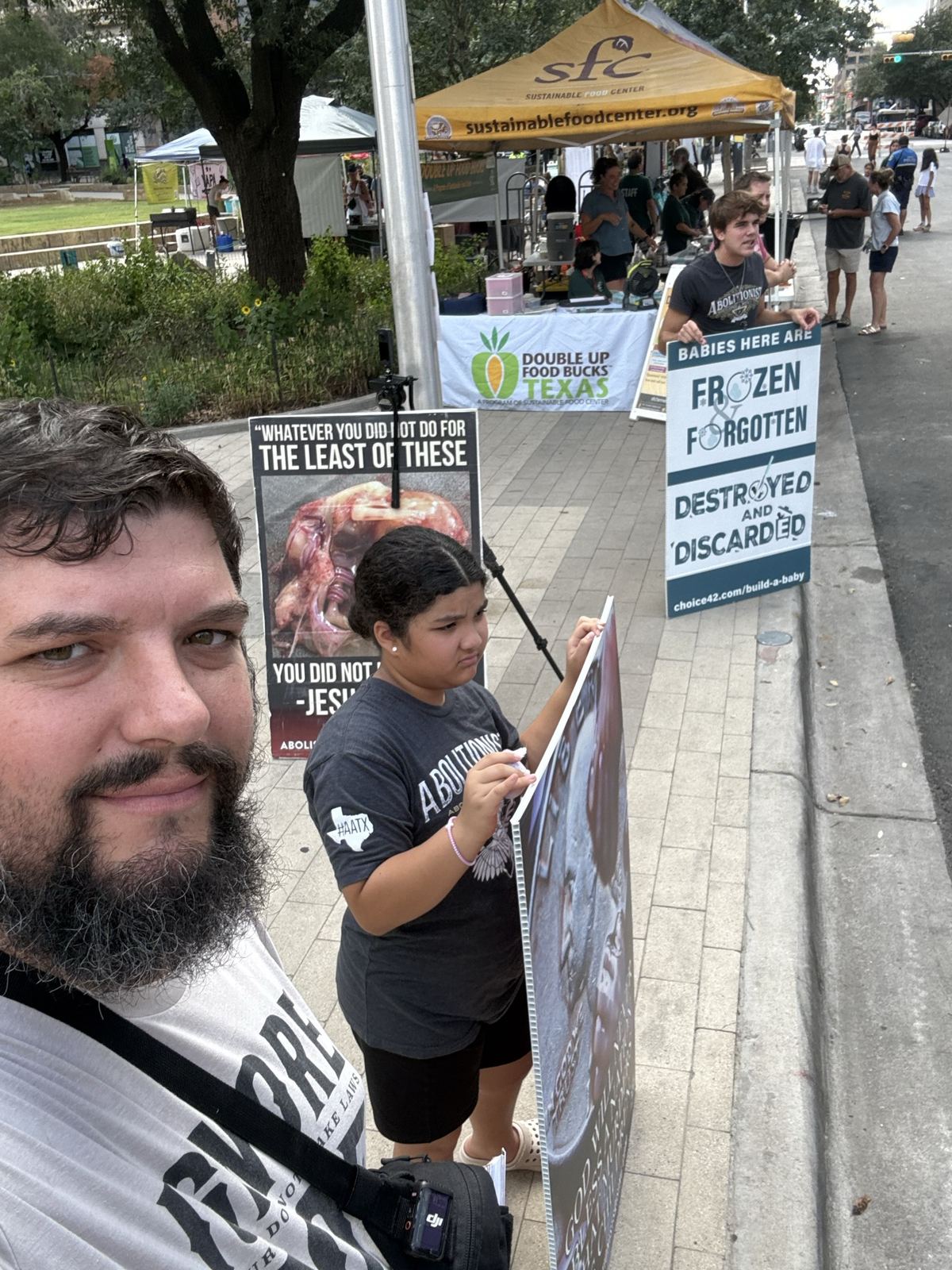 Outreach beside signs at a farmers market