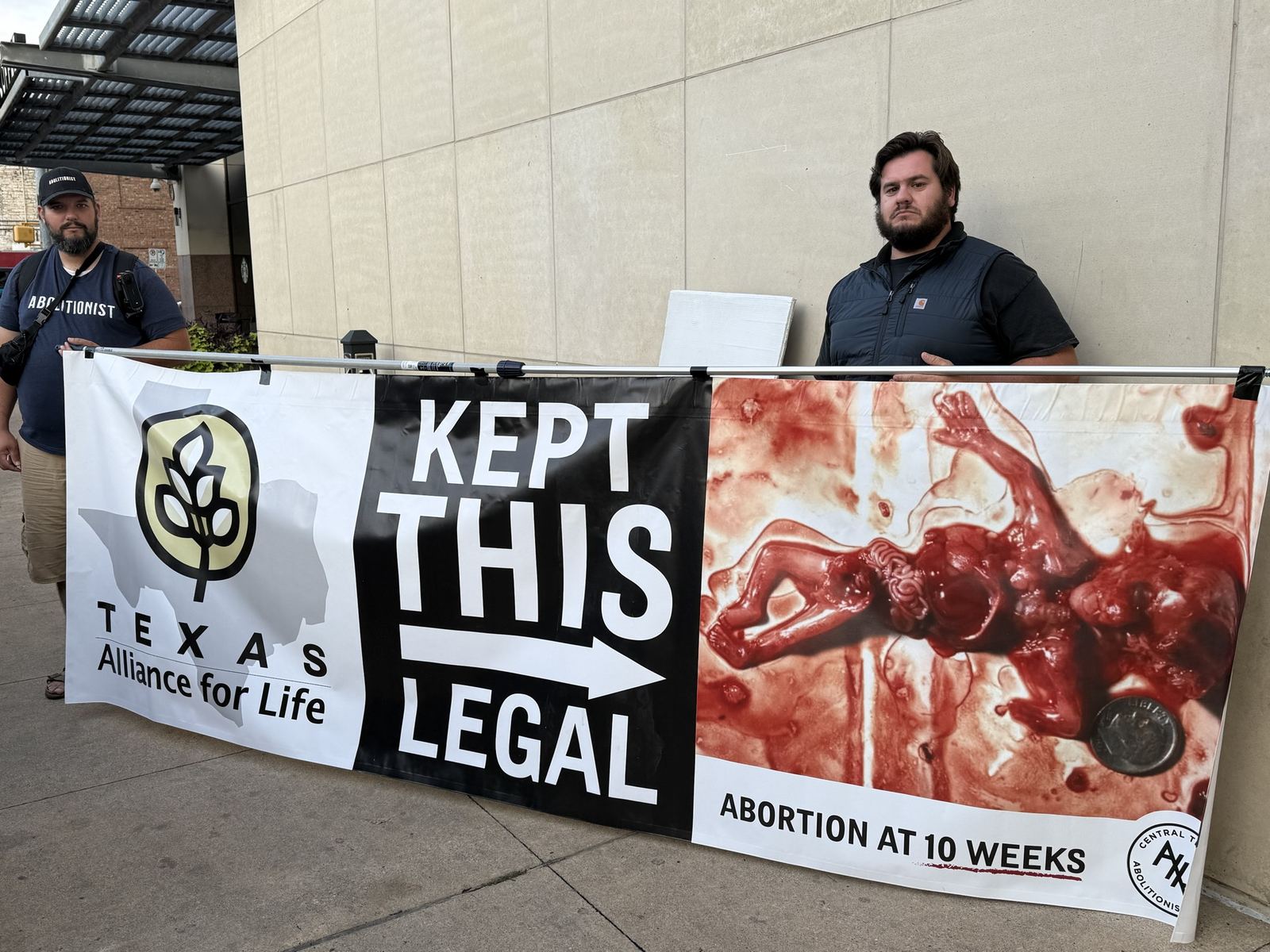 Two men holding a banner about abortion kept legal in Texas